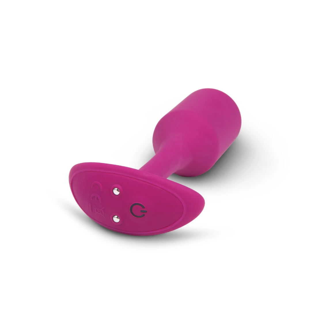 Korek analny wibrujący wykonany z silikonu w kolorze fuksji B-Vibe Vibrating Snug 
