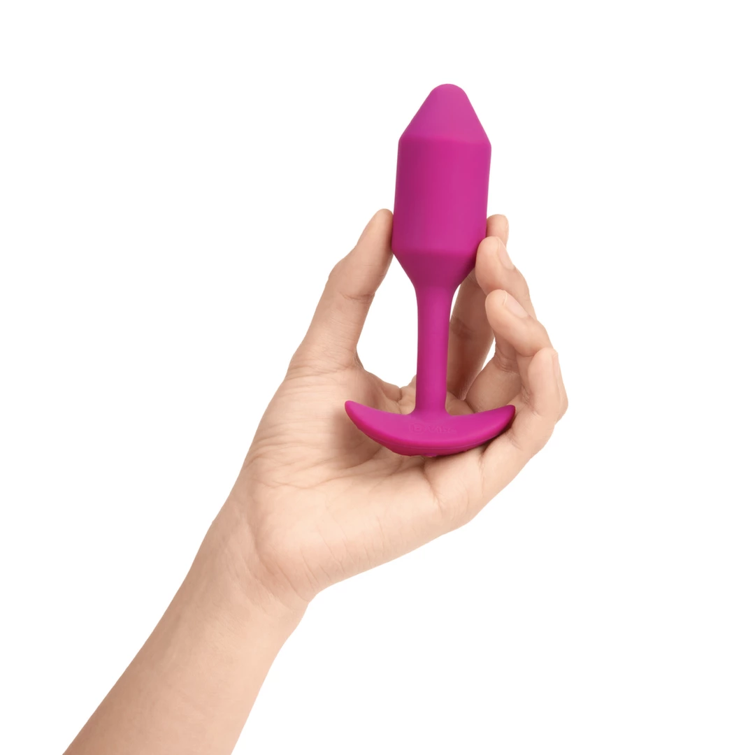 Korek analny wibrujący wykonany z silikonu w kolorze fuksji B-Vibe Vibrating Snug 